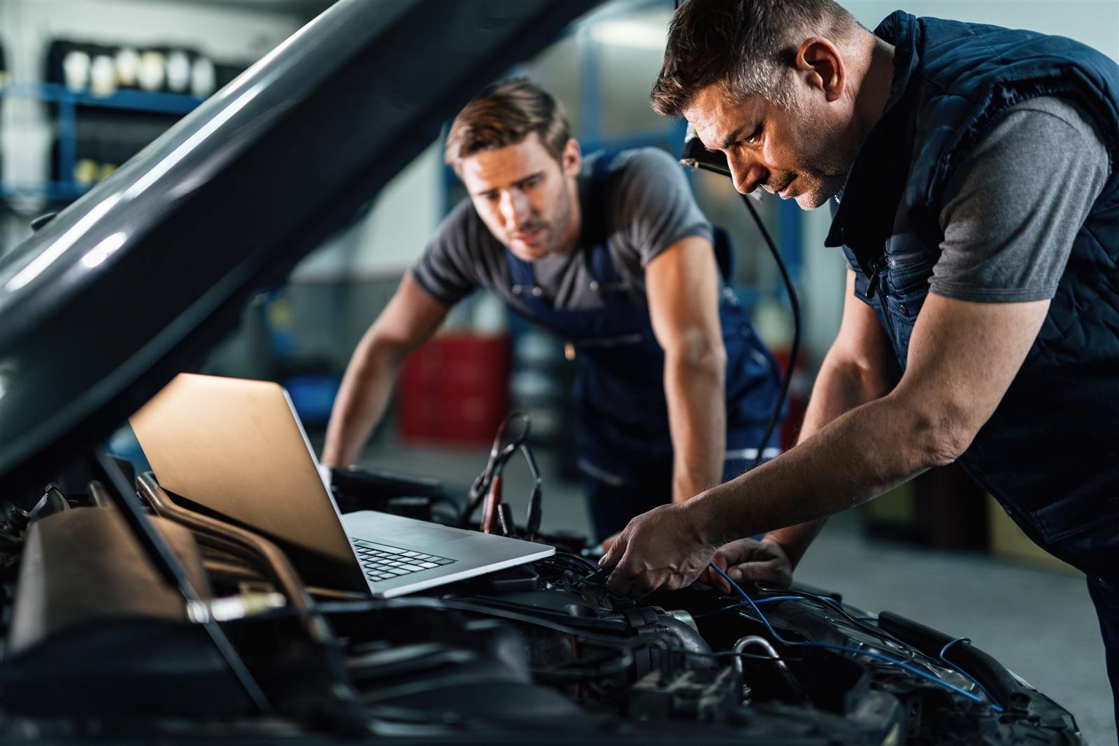 Mecânicos avaliando o carro com o computador de diagnóstico